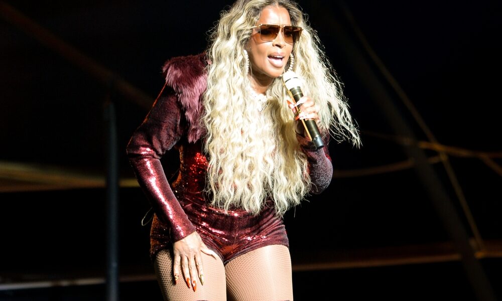 Mary J. Blige performing live on stage with a microphone